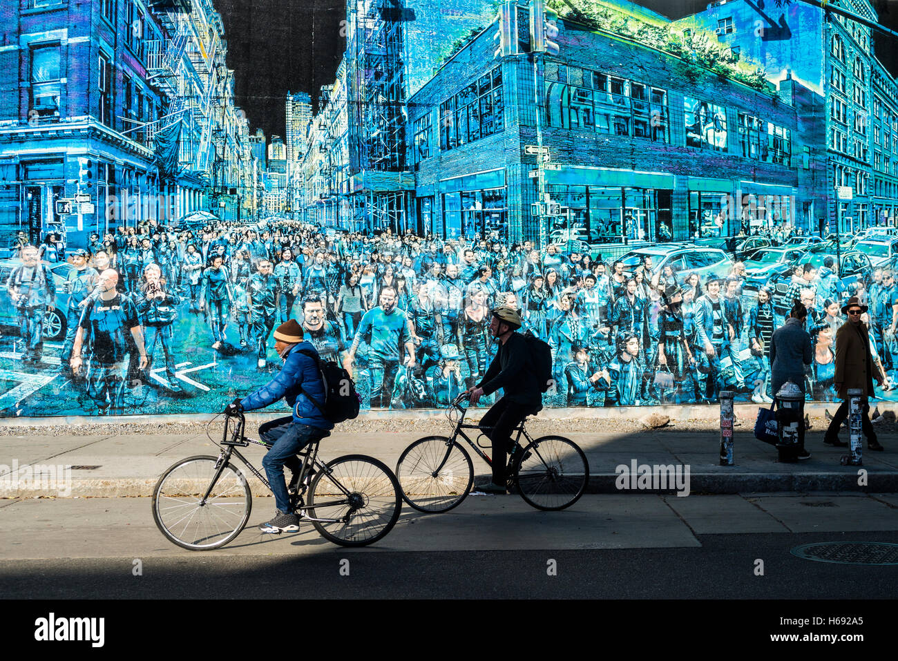 New York, NY - Cyclists and pedestrians n the East Village, pass a mural by Logan Hick,  entitled Story Of My Life, which features a crowd of people he photographed on the corner of Spring and Greene Street. ©Stacy Walsh Rosenstock Stock Photo