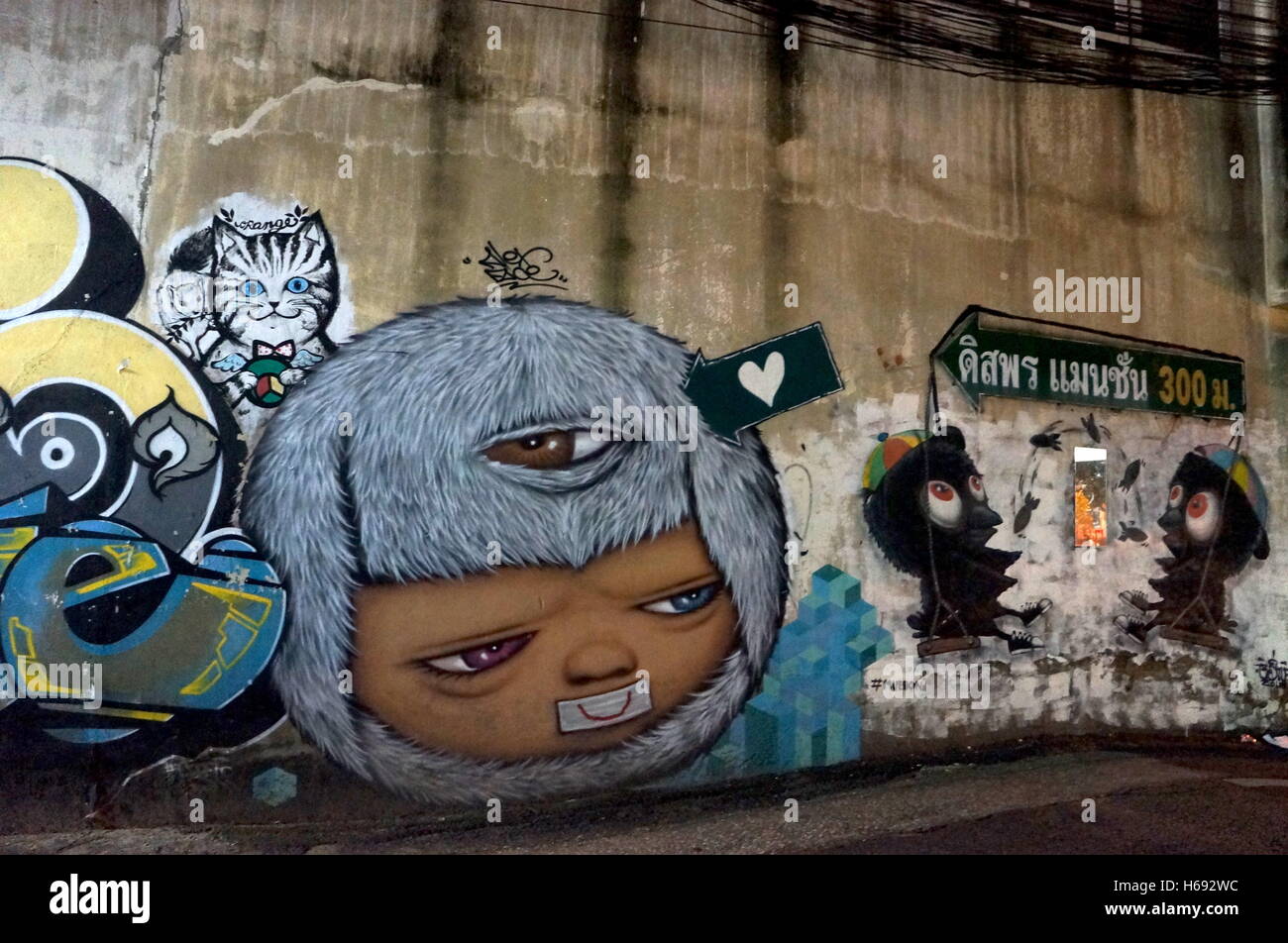 A painting by street artist activist Pattcharapon ‘Alex Face’ Tangreun on a wall in downtown Bangkok Stock Photo