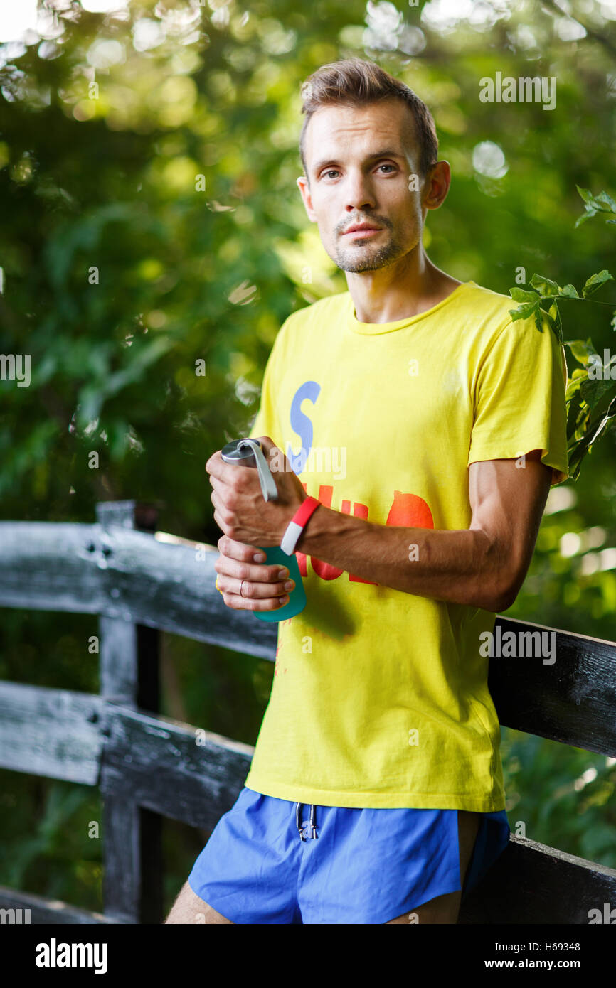 Young athlete closeup with water bottle in hand in park Stock Photo - Alamy