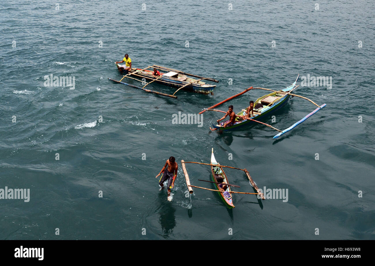 Badjao sea gypsies collecting coins thrown at them from a ferry boat in Batangas, Philippines. Stock Photo