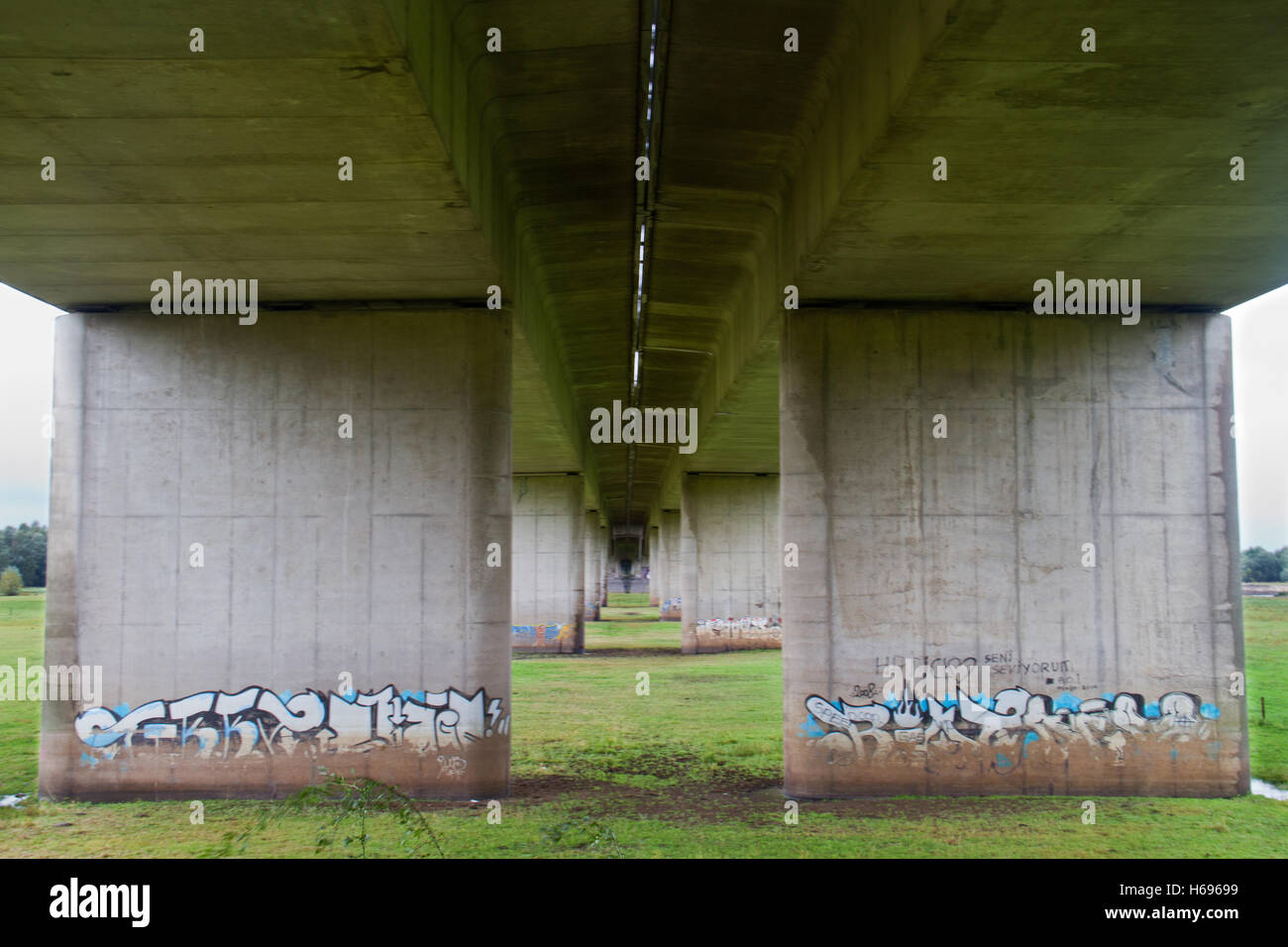 Graffiti on pillars of the road bridge over the Ijssel river and its floodplain near Deventer in the Netherlands Stock Photo