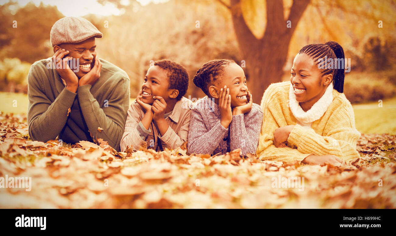 Portrait of a young smiling family lying in leaves Stock Photo