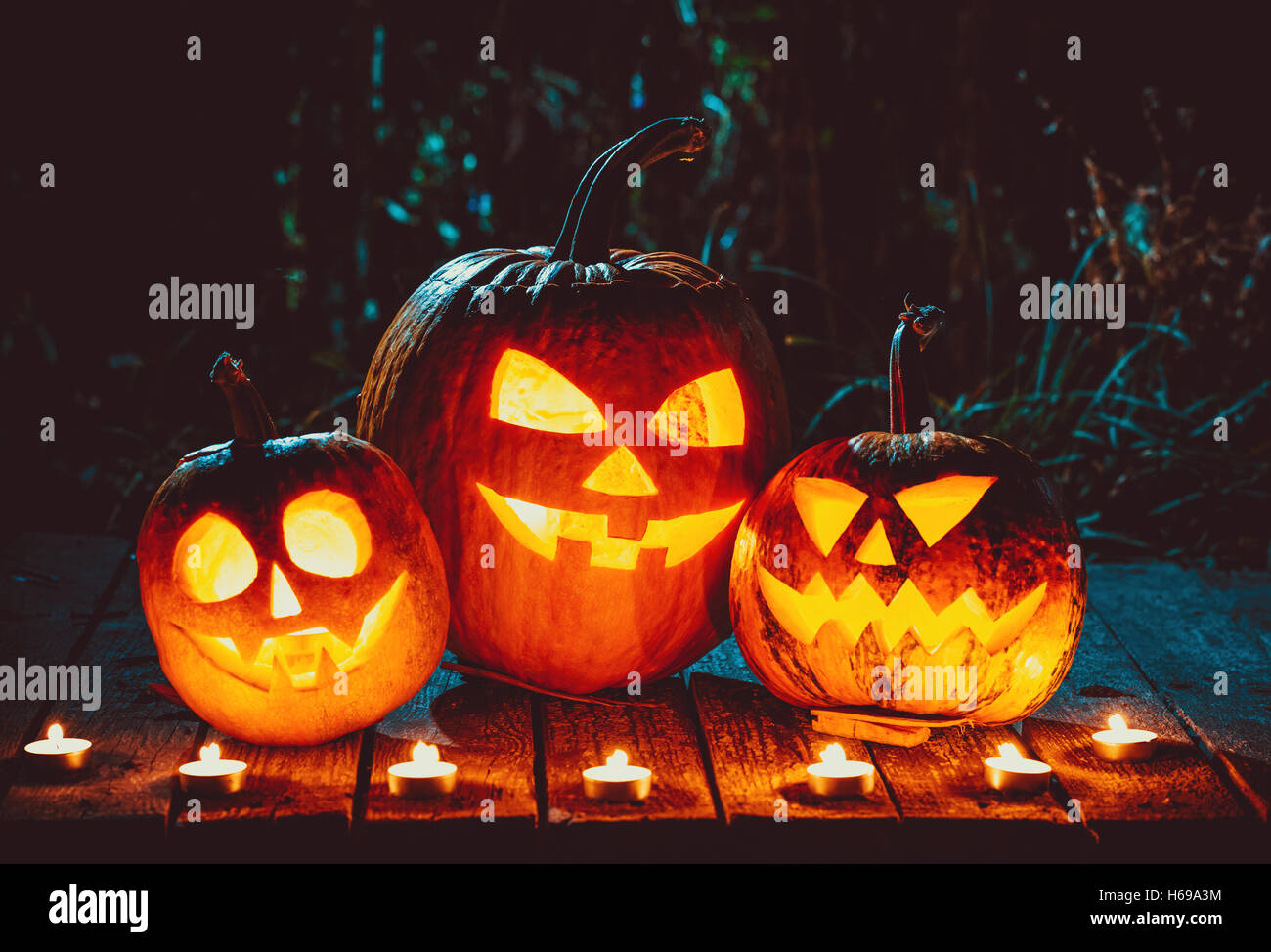 Halloween pumpkins head jack lantern with candles around on the old ...