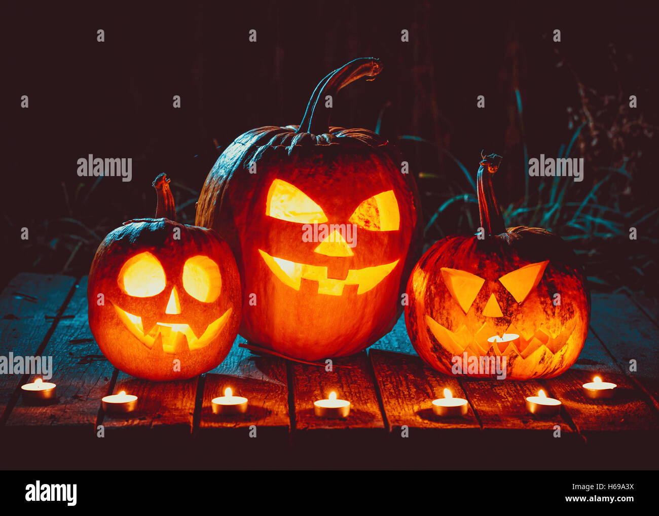 Halloween pumpkins head jack lantern with candles around on the old ...