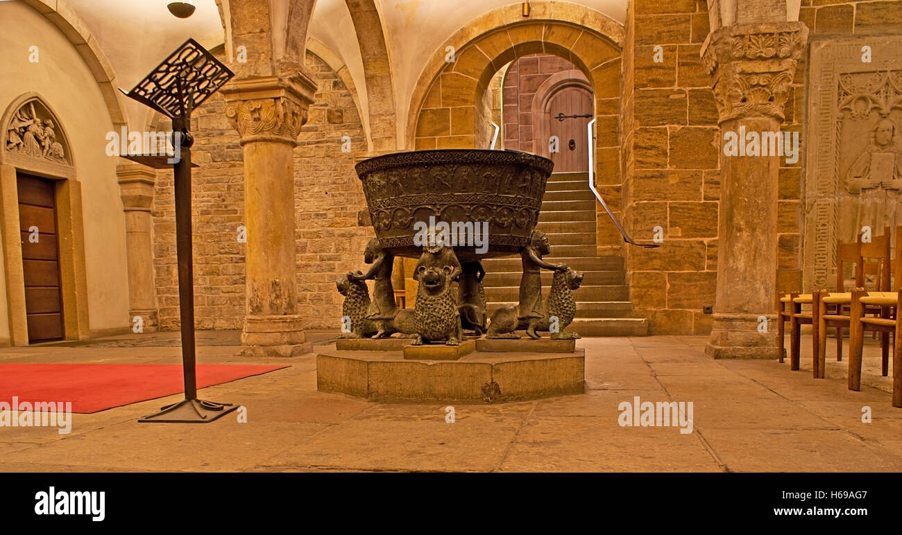 The medieval crypt of St Peter's cathedral with the Celtic-era cauldron, decorated with men sitting on lions Stock Photo