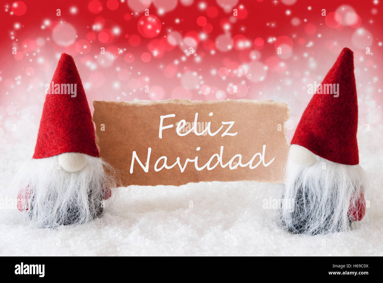 Red Christmassy Gnomes With Card, Feliz Navidad Means Merry Christmas Stock Photo