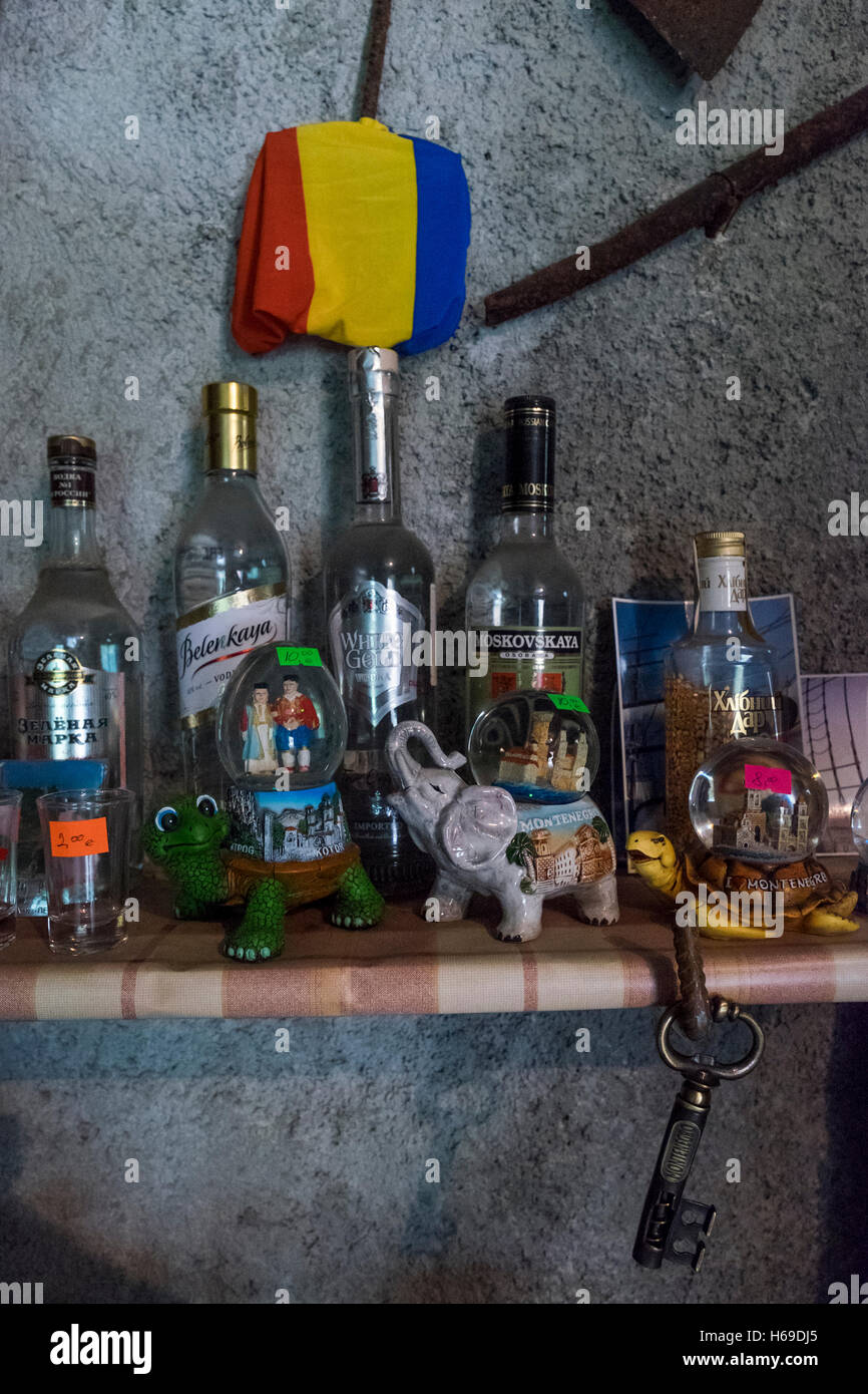 Russian vodka and Montenegran souvenirs on display by a tiny Russian flag at Sušara Smokehouse. The smokehouse sells Njeguška pr Stock Photo