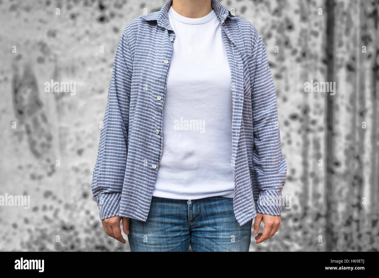 A casual girl wearing jeans and a plaid shirt with clean white t-shirt as copy space for graphic design print mock up. Stock Photo