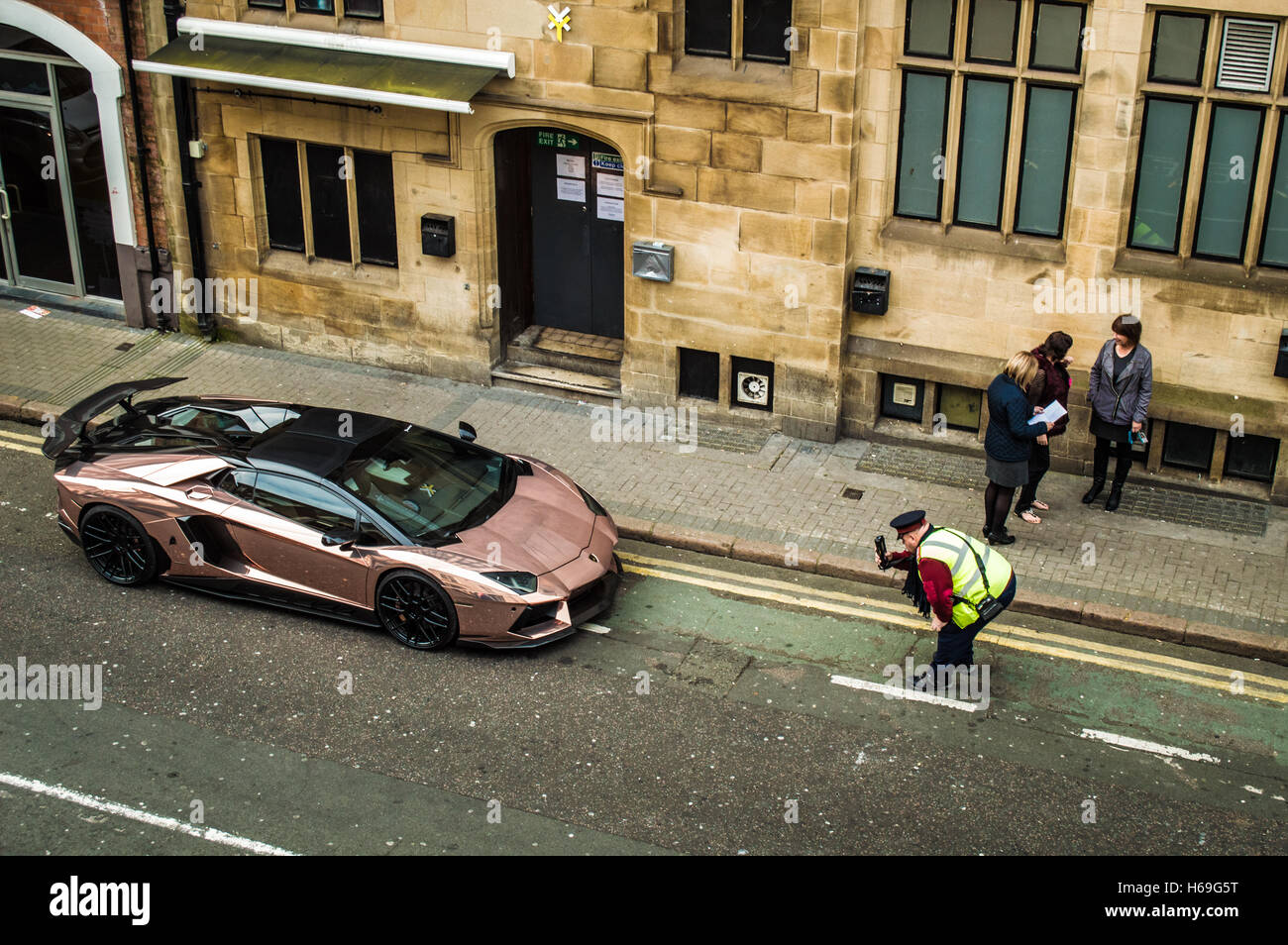 Traffic Enforcment Officer recording Illegally parked Lamborghini in Leicester Stock Photo