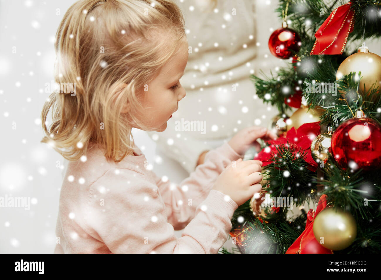 little girl decorating christmas tree at home Stock Photo - Alamy
