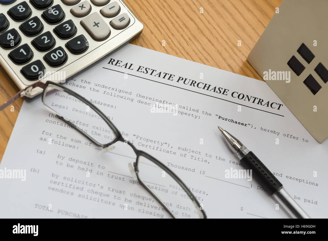 real estate purchase contact with an architectural model and a calculator Stock Photo