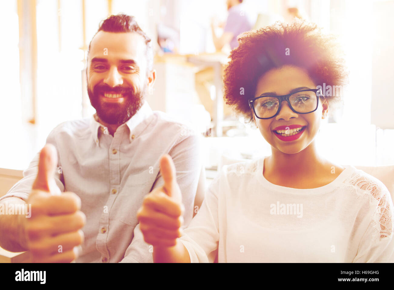 happy creative team in office showing thumbs up Stock Photo - Alamy