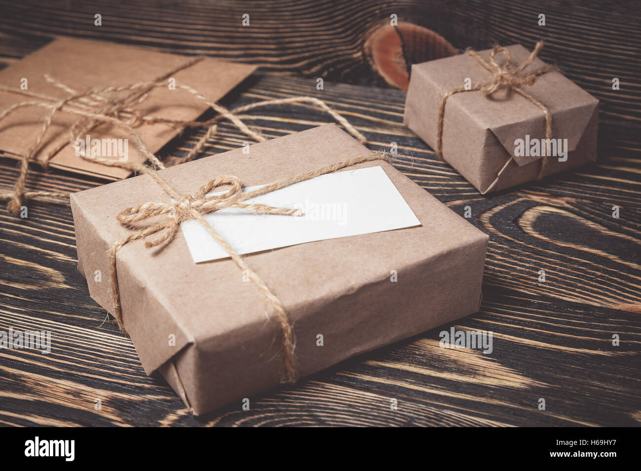 Vintage gift box with blank tag on old wooden background. Stock Photo