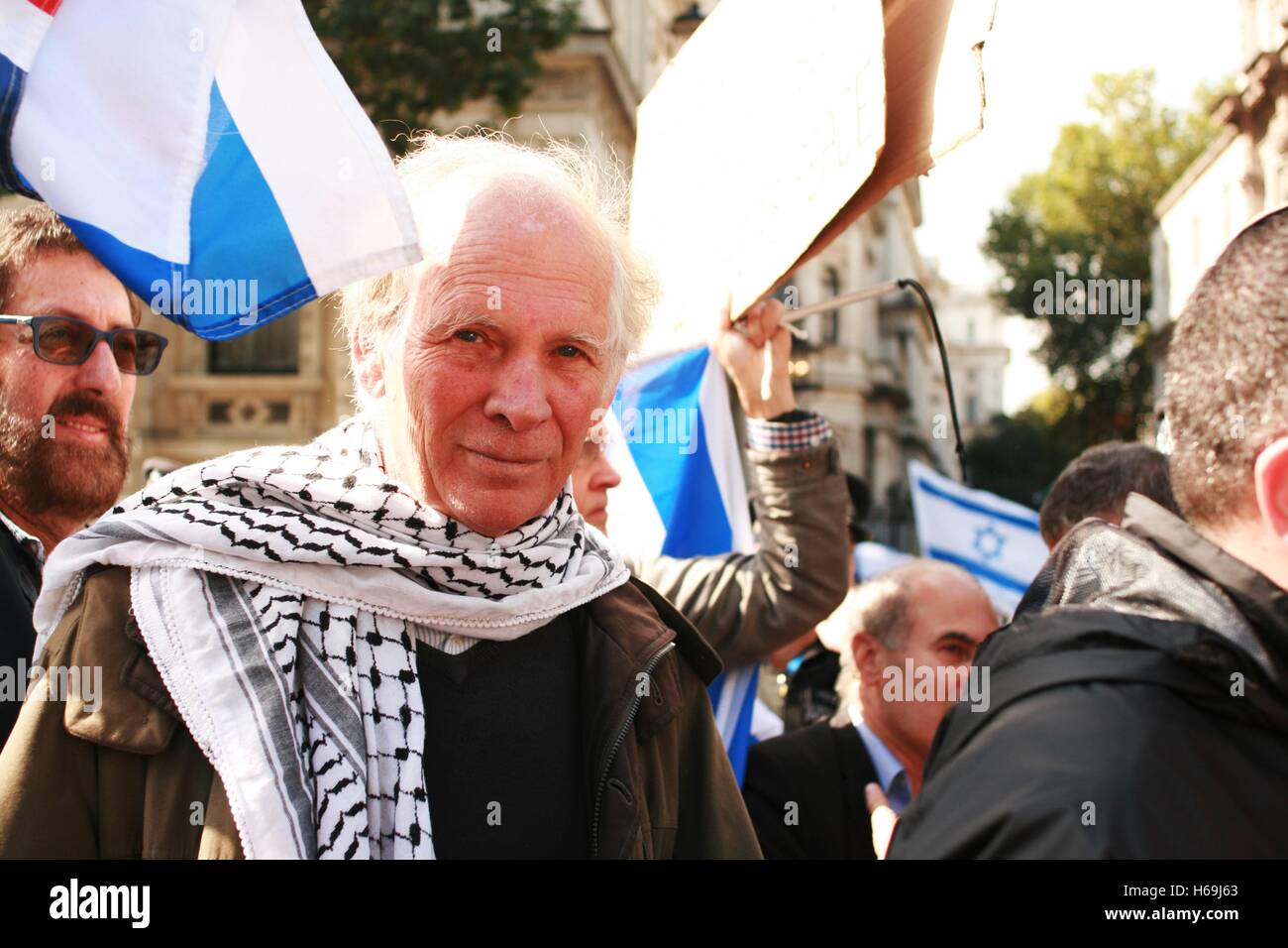 A Palestinian solidarity campaigner stands with British Zionists during a protest against the state visit of Israeli PM Benjamin Netanyahu, who campaigners say has committed war crimes in Gaza. The protesters have also submitted a 100,000 signatory petition for Netanyahu to be convicted of war crimes, while he visits the United Kingdom. Stock Photo