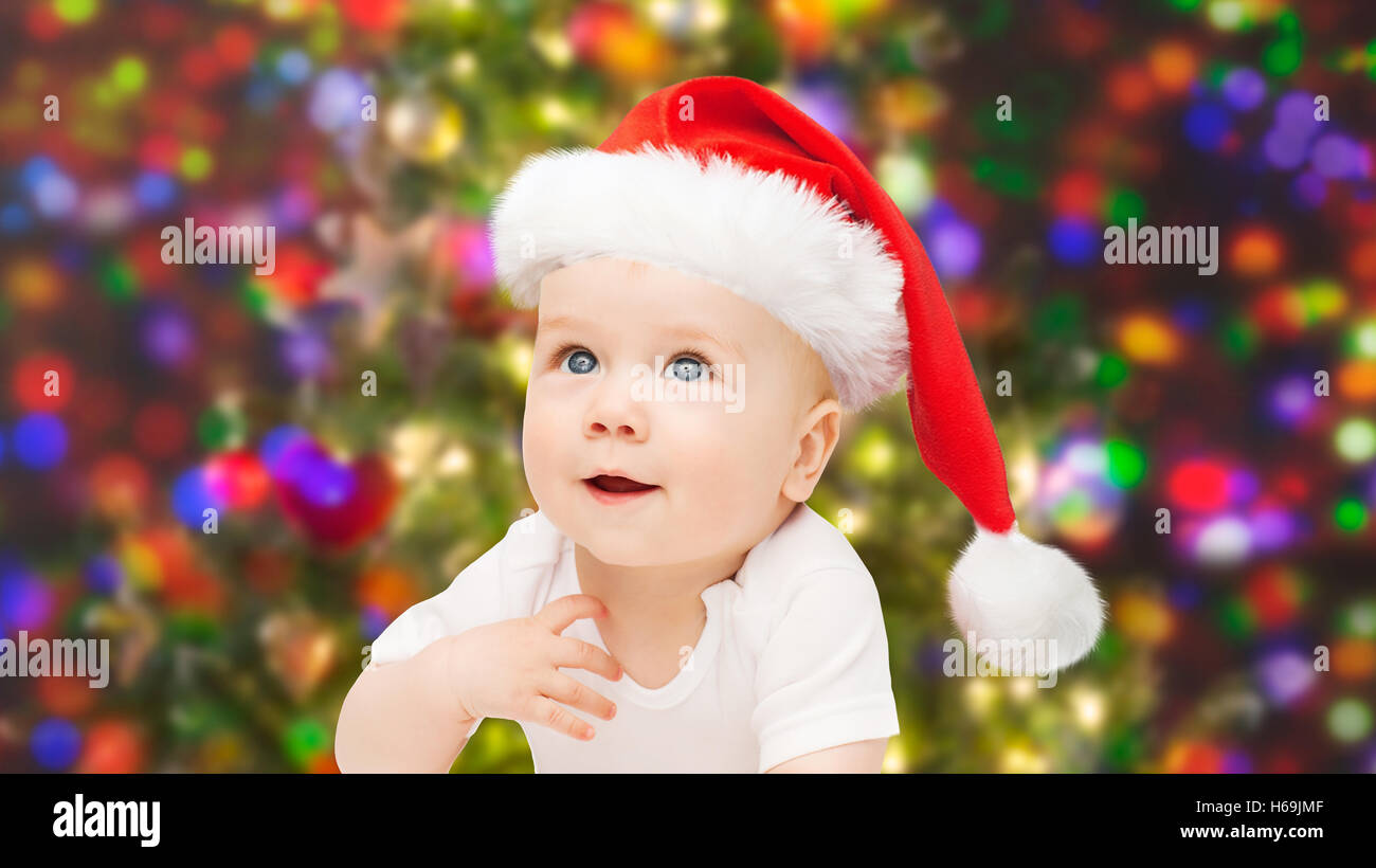 baby boy in christmas santa hat over blue lights Stock Photo Alamy