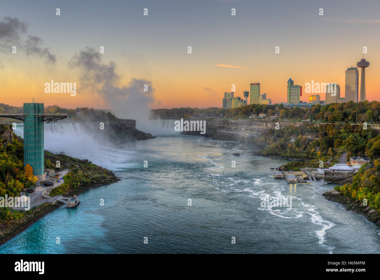 The Niagara River including the American Falls, Horseshoe Falls, and skyline of Niagara Falls, Ontario just before sunrise. Stock Photo