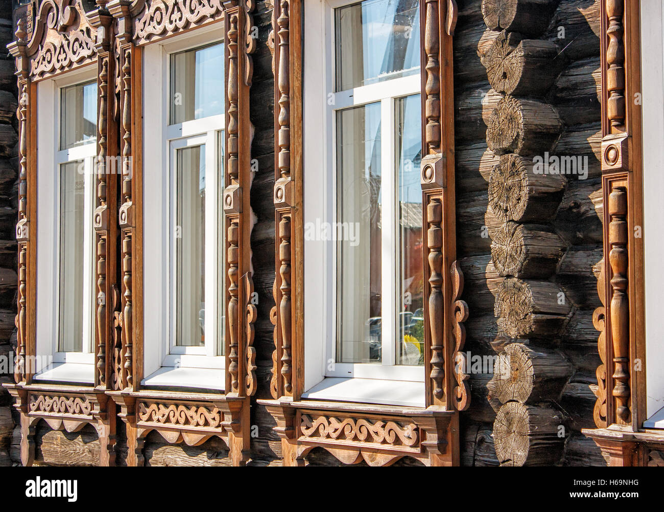 carved wooden window frames on the old house on summer day Stock Photo