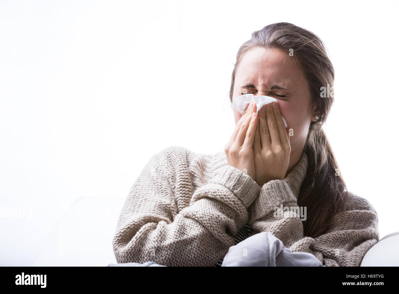 woman blowing her nose because of a cold or a strong allergy or intolerance Stock Photo