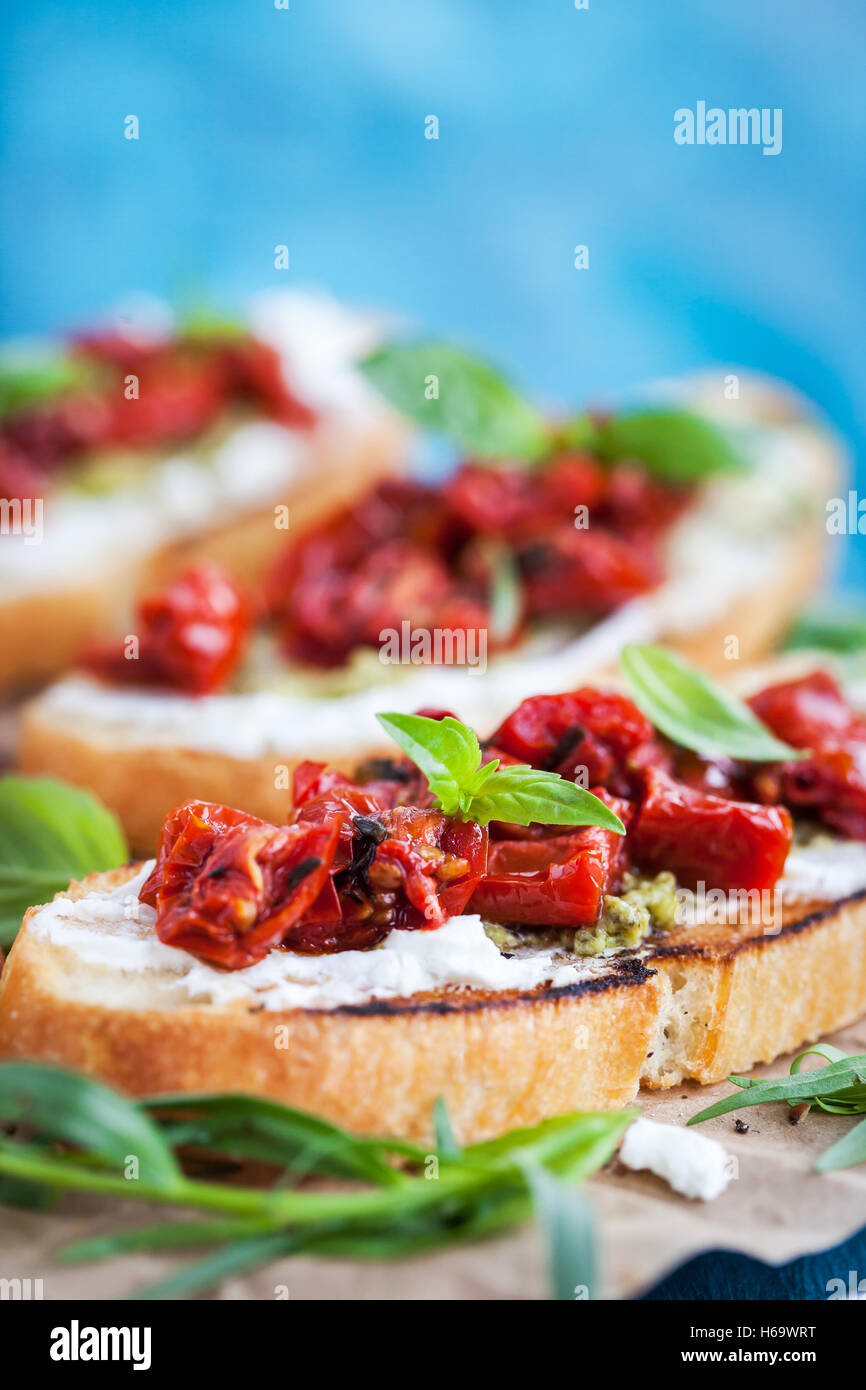 Bruschetta with cream cheese, pesto, fresh basil and sun dried tomatoes