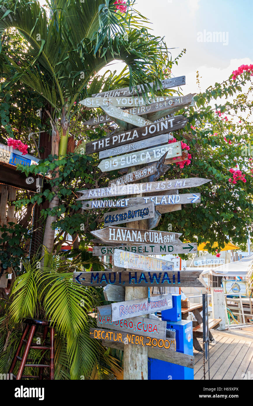 Assortment of mileage signs outside Hogfish Bar & Grill. A great, local, authentic place for fish in the Florida Keys Stock Photo