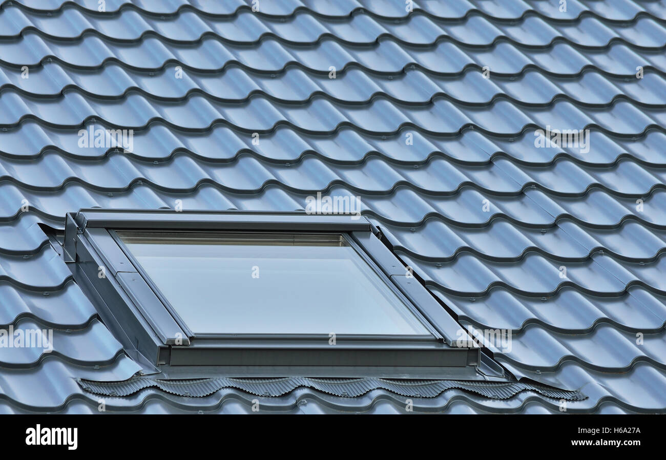Roof window on a gray tiled rooftop, large detailed loft skylight