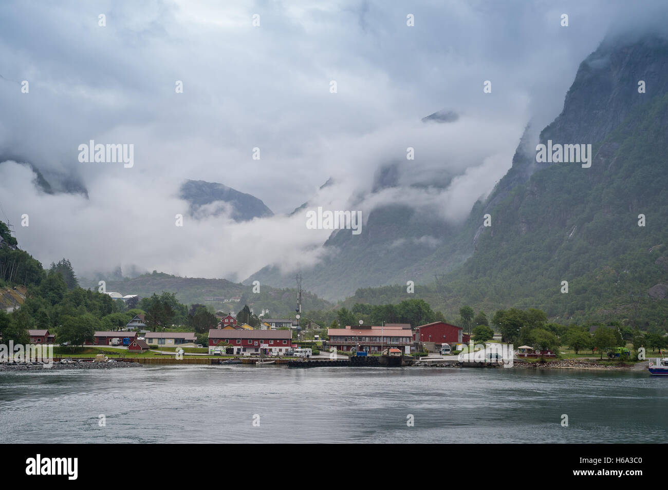 Norwedian village under the mountains in cluds and fog. Stock Photo
