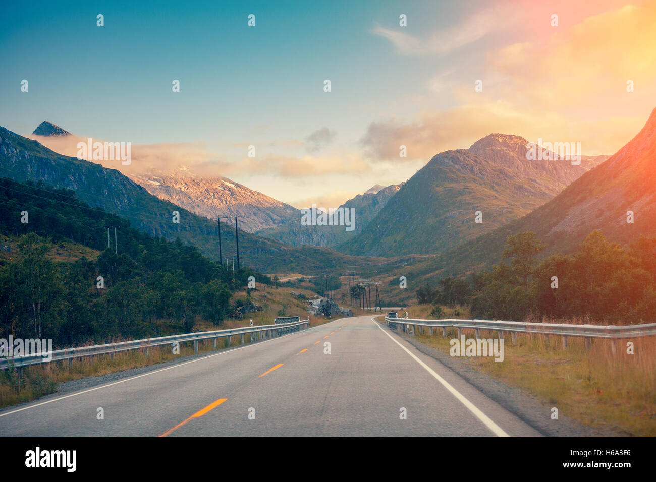 Mountain road at sunset with blue light cloudy sky Stock Photo - Alamy