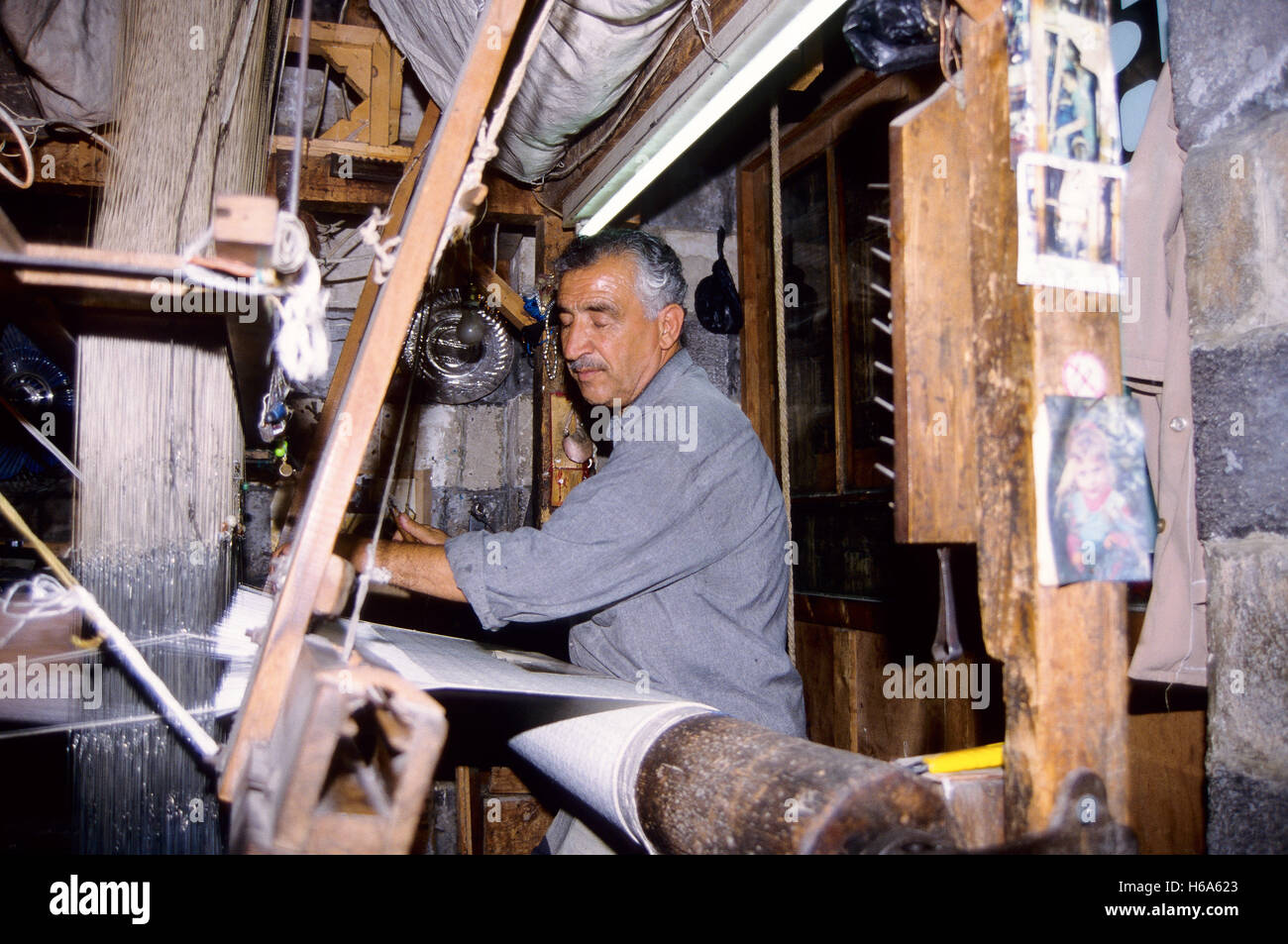 Abu Sayyah, one of the last brocade weavers in the Syrian capital. Taken on 12.08.1995. Every day Abu Sayyah stands behind his mechanical loom and with great concentration manages to weave around a metre of brocade fabric. Photo: Matthias Tödt  | usage worldwide Stock Photo