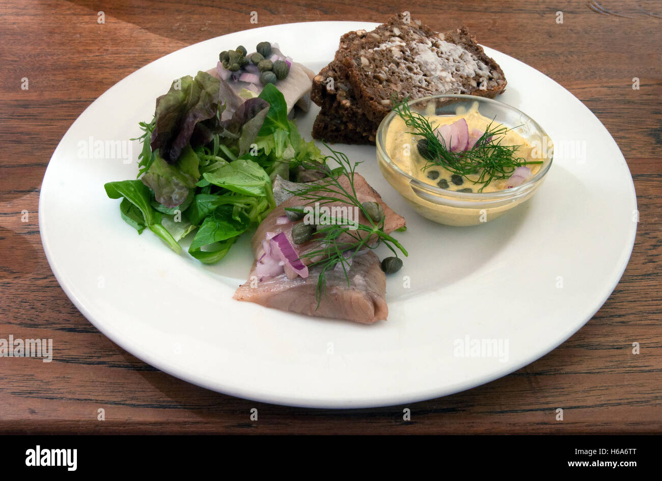 cured and pickled herring with ryebread, capers and curry mayonnaise Stock Photo