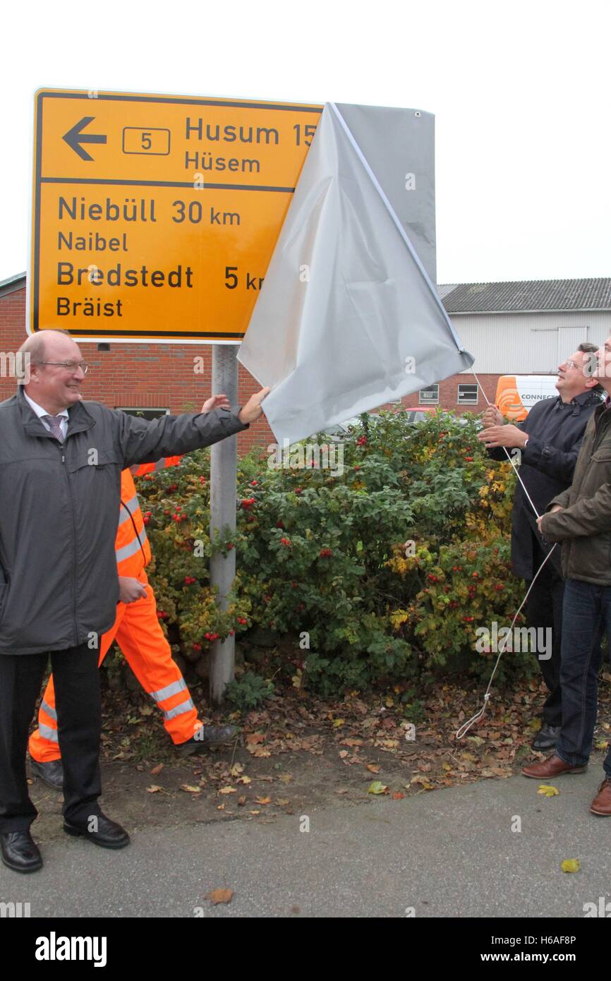 Struckum, Germany. 26th Oct, 2016. District administrator of North Frisia, Dieter Harrsen, State Transport Minister Reinhard Meyer, and member of the state parliament, Lars Harms, unveil a dual-language sign written in German and Frisian on Federal Road 5 at the entrance to Struckum, Germany, 26 October 2016. In the district of North Frisia and on the island of Heligoland, Frisian is, next to German, the second administrative language. Photo: WOLFGANG RUNGE/dpa/Alamy Live News Stock Photo