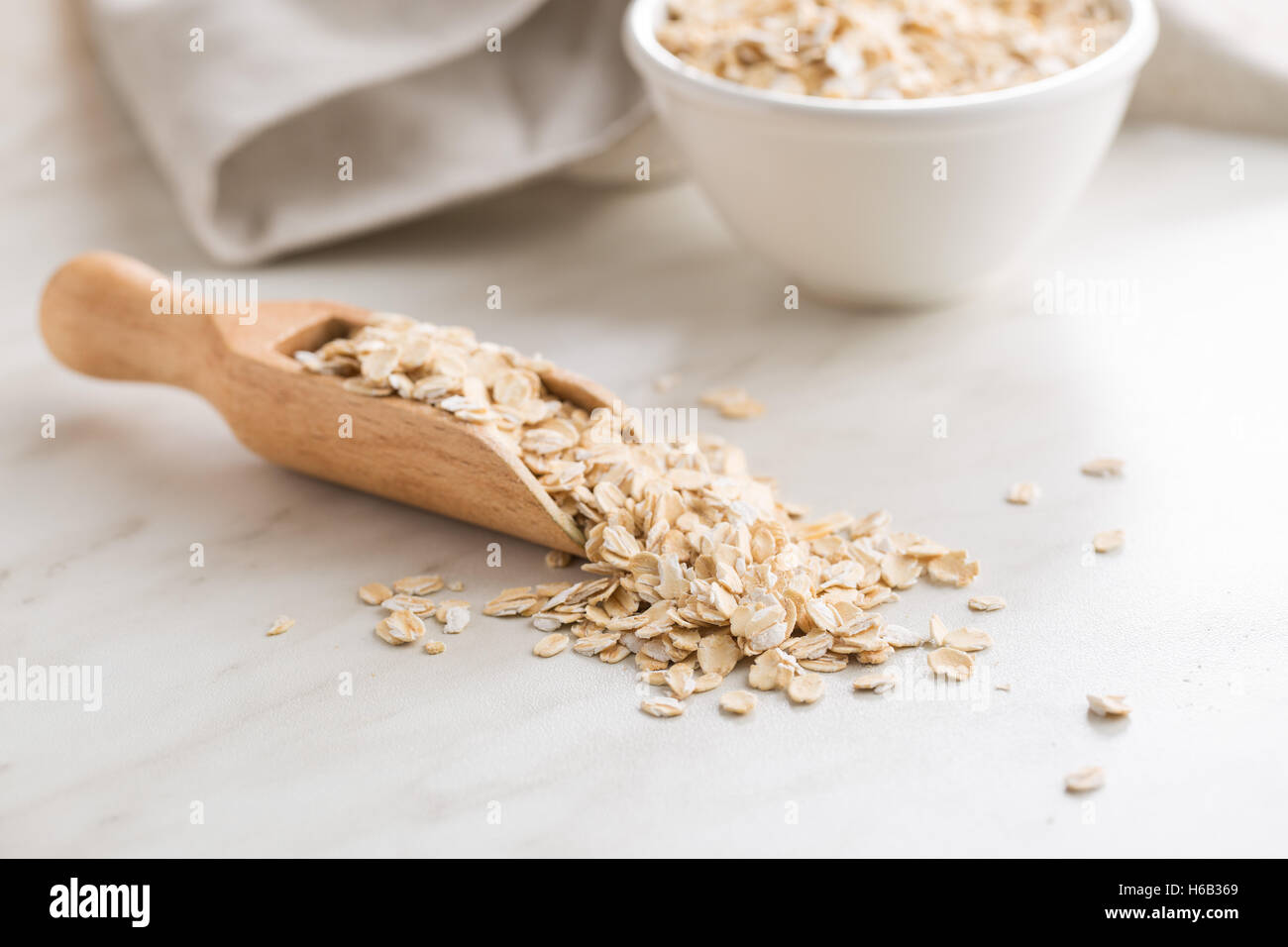 Dry rolled oatmeal in wooden scoop. Stock Photo
