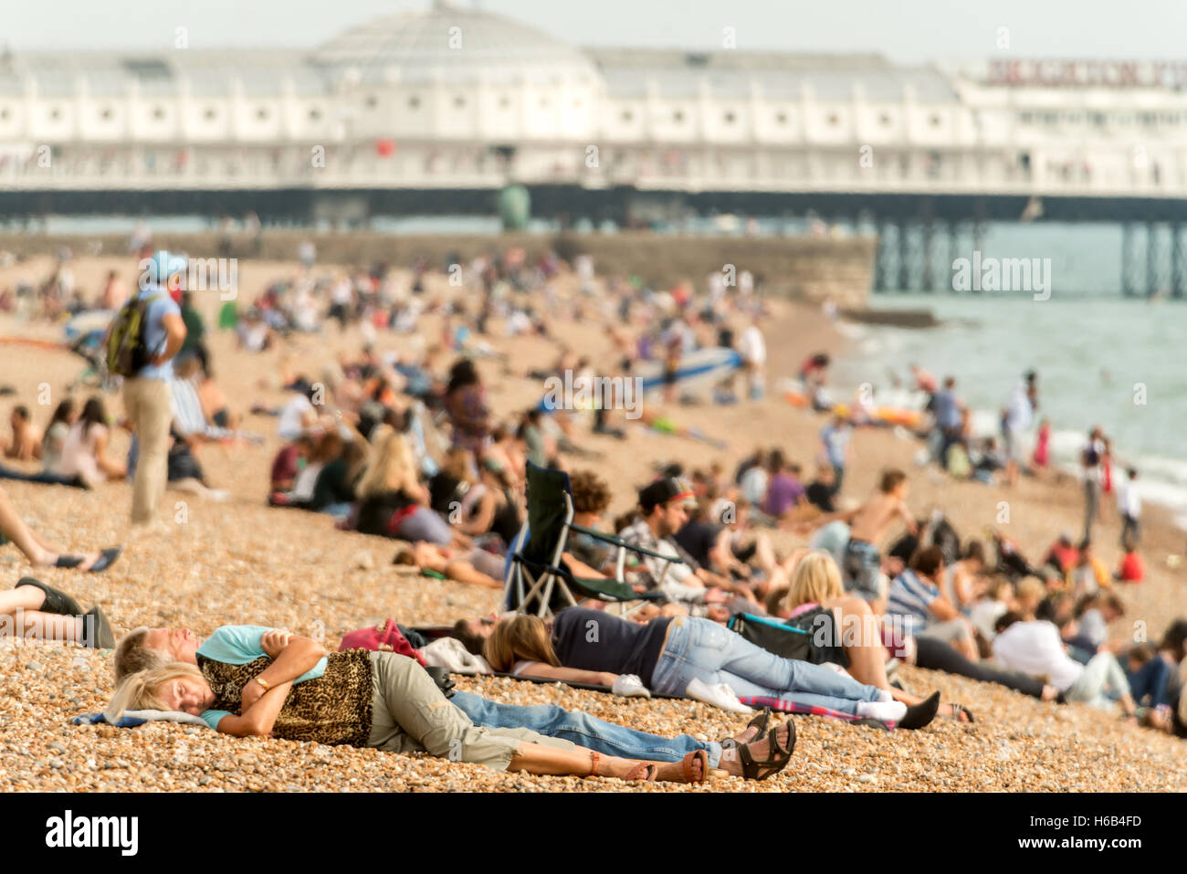 Surfers and sunbathers on Brighton beach Stock Photo