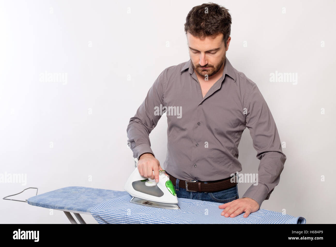 Portrait of single man ironing a shirt Stock Photo Alamy