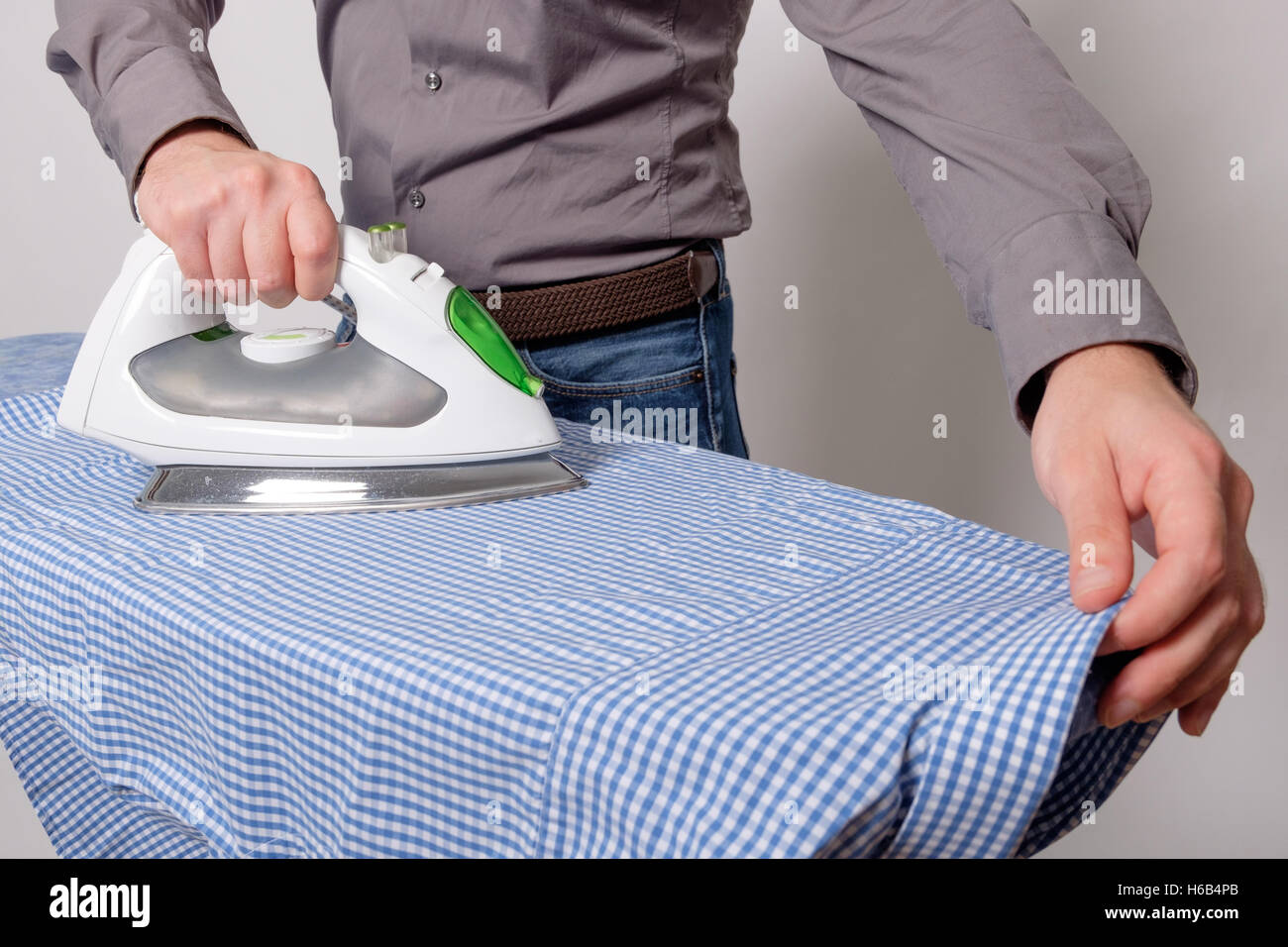 Close up of man's hands ironing a shirt Stock Photo