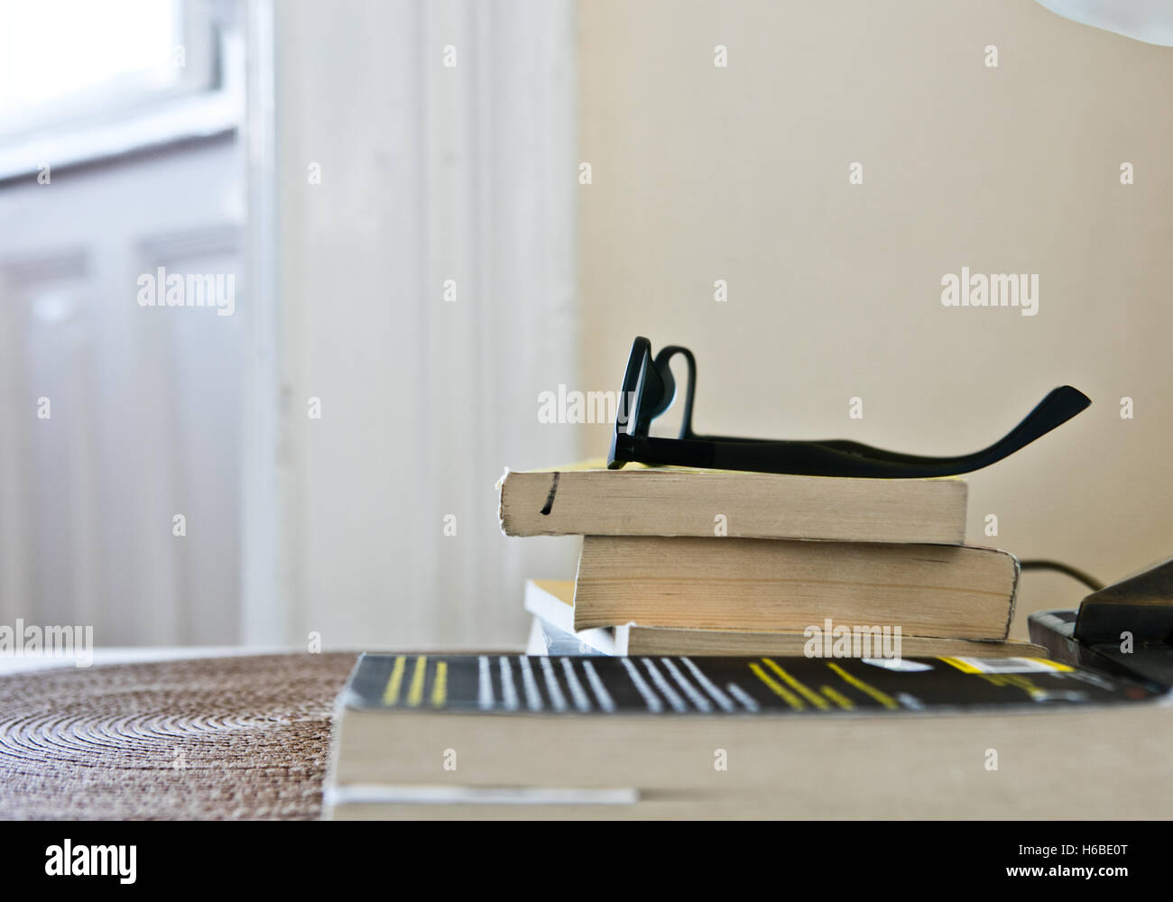 Closeup of stack of books with reading glasses Stock Photo