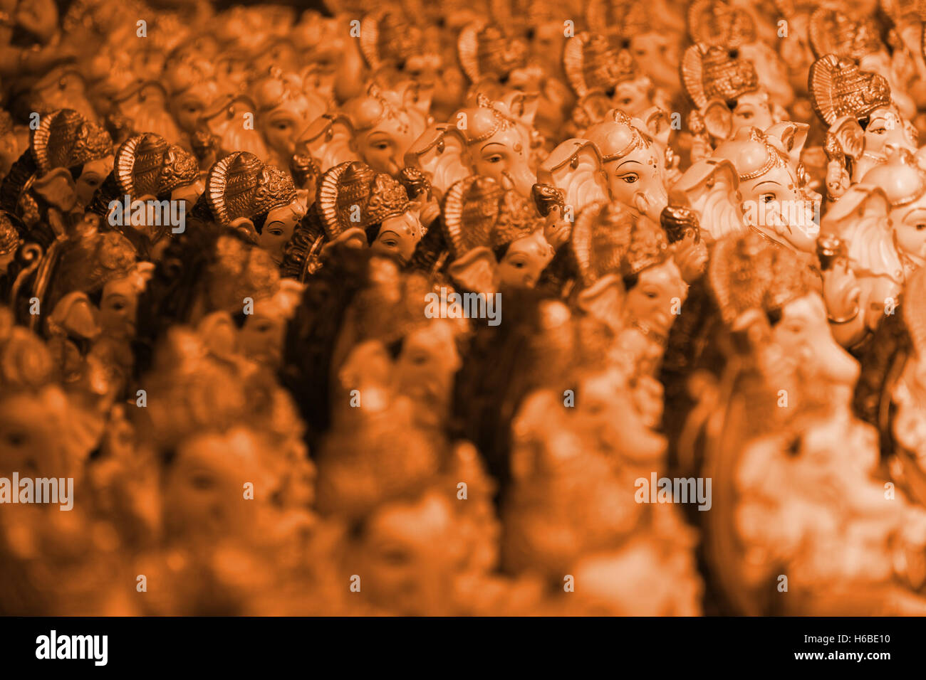 A background with many idols of lord ganesha in saffron color which represents hinduism Stock