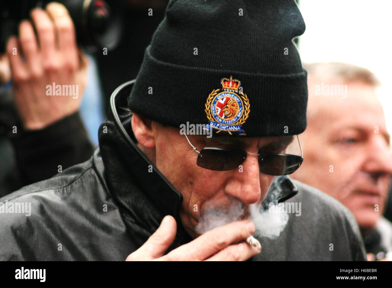 A member of Britain First inhales on a cigarette as the nationalist 'Christian vanguard' group protests on Piccadilly Circus - a counter movement to the anti-fascist march in London. Stock Photo