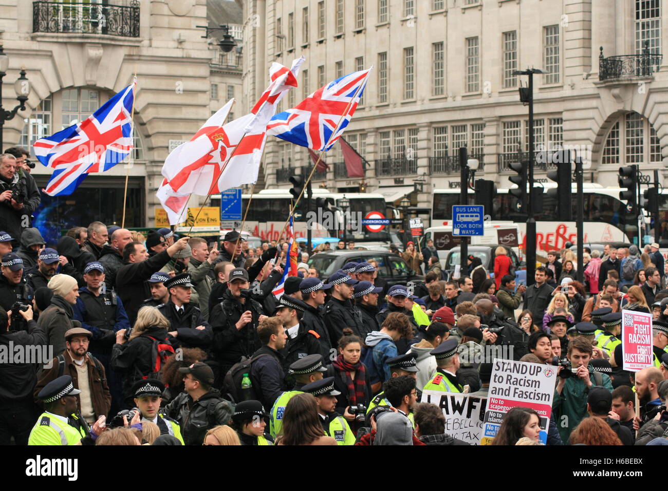 Nationalist 'Christian vanguard' group Britain First demonstrate counter to anti-fascist protesters who have come out in the streets of London to protest against the far right and racism on Piccadilly Circus. The protests are separated by a line of police officers. Stock Photo