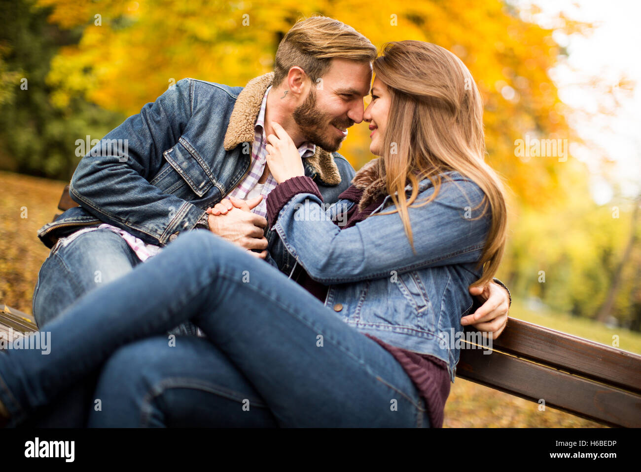 Loving and romantic couple on a bench in the autumn park Stock Photo ...
