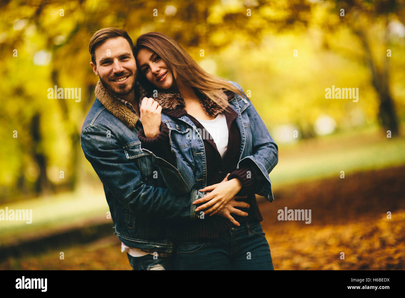 Young couple posing in the autumn park Stock Photo - Alamy