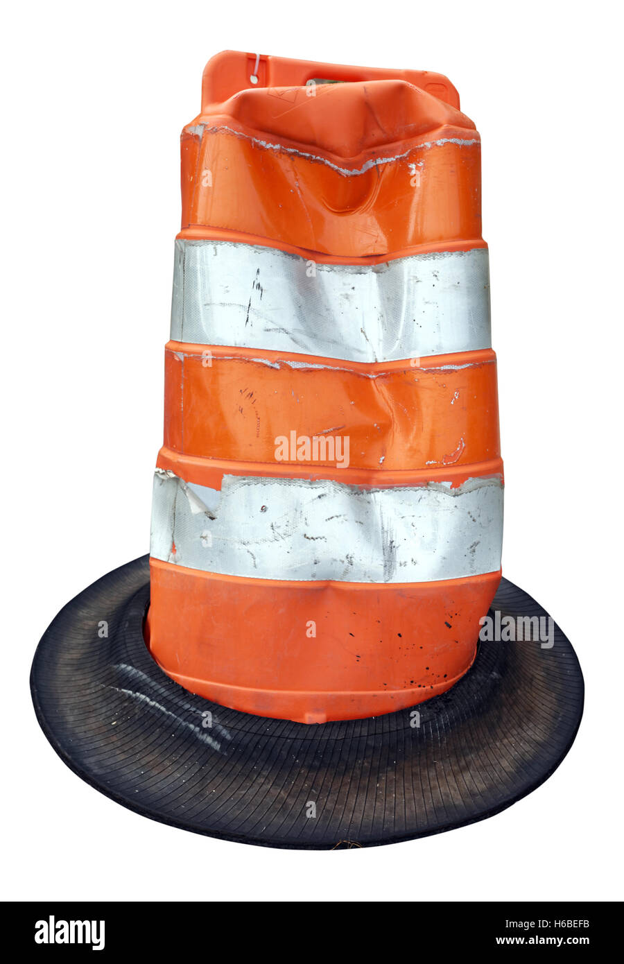 Battered orange and white striped traffic construction cone resembling a Cat in the Hat hat. Isolated on white. Stock Photo