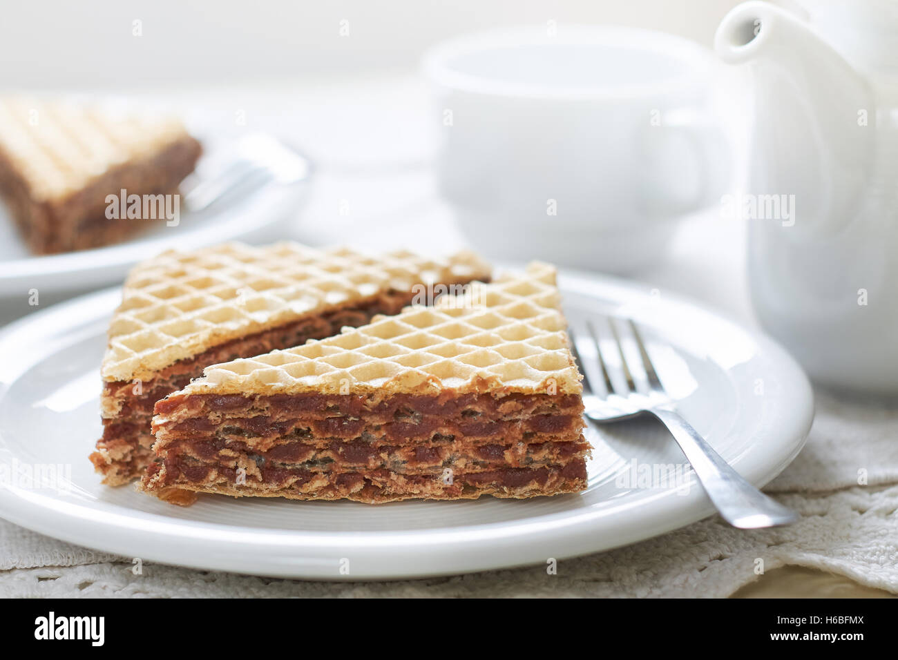 Wafer sheets filled with caramelized sugar and hazelnut cream served on white plate Stock Photo
