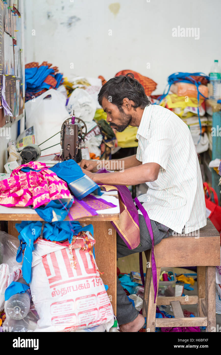 Indian man using a sewing machine in a back street near to the Kapaleeshwarar Temple, Mylapore