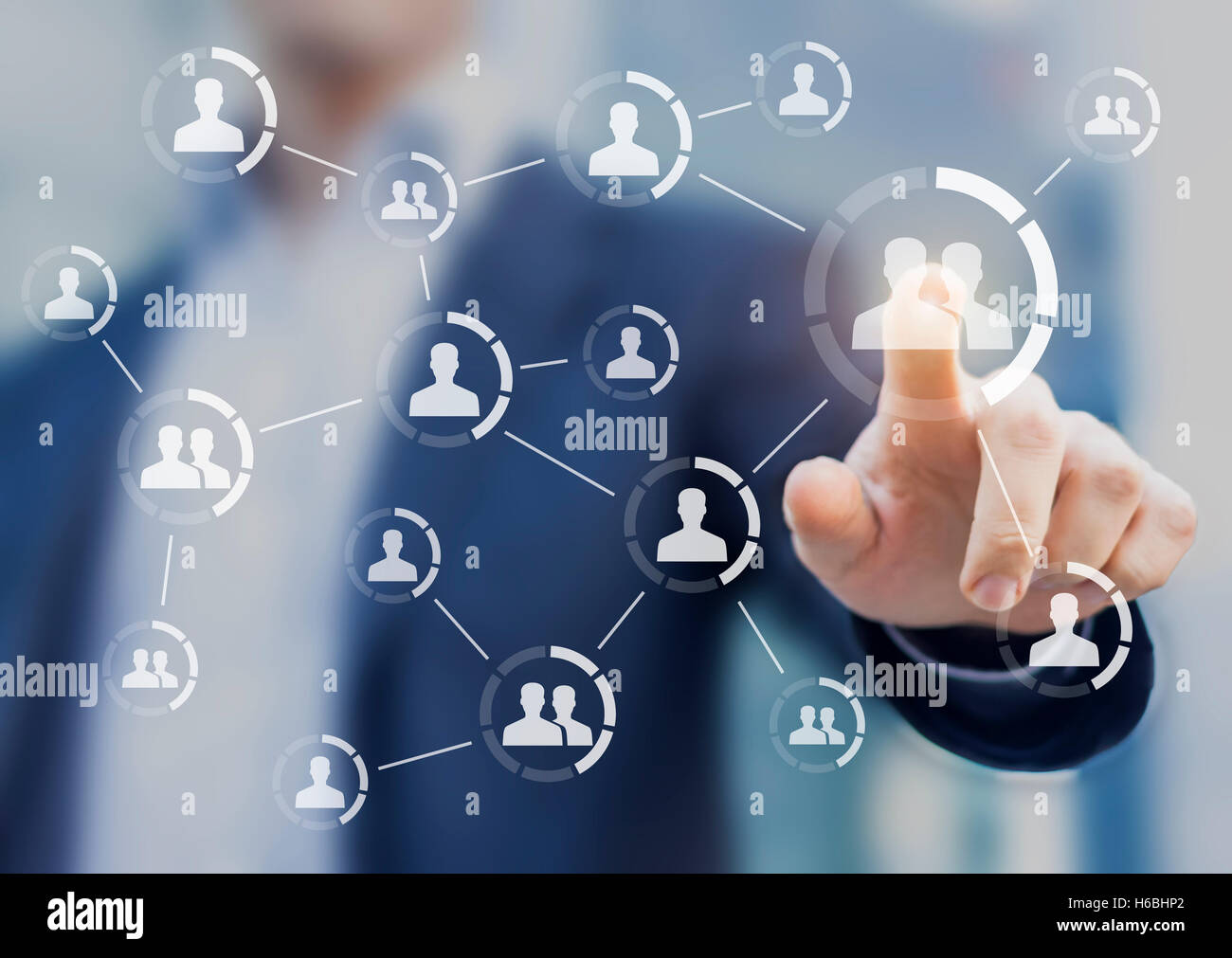Connections between people displayed on a screen with hand touching icon in background. Concept about friendship and communities Stock Photo