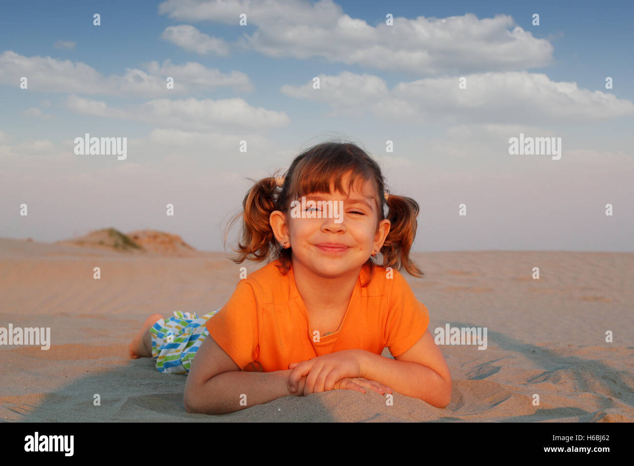 happy little girl lying on beach Stock Photo Alamy