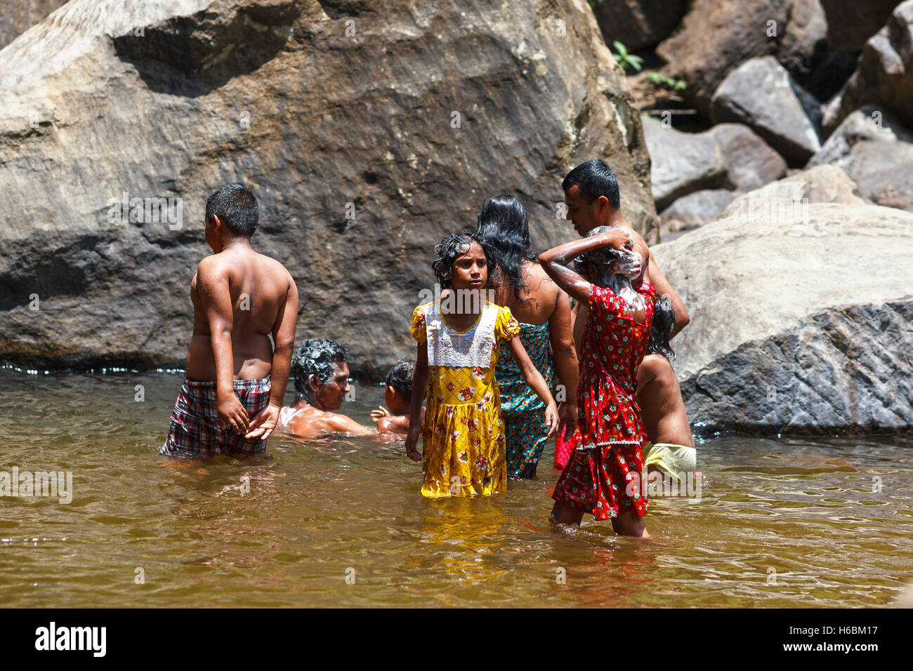 Local Sri Lankan family bathes in a waterfall Stock Photo