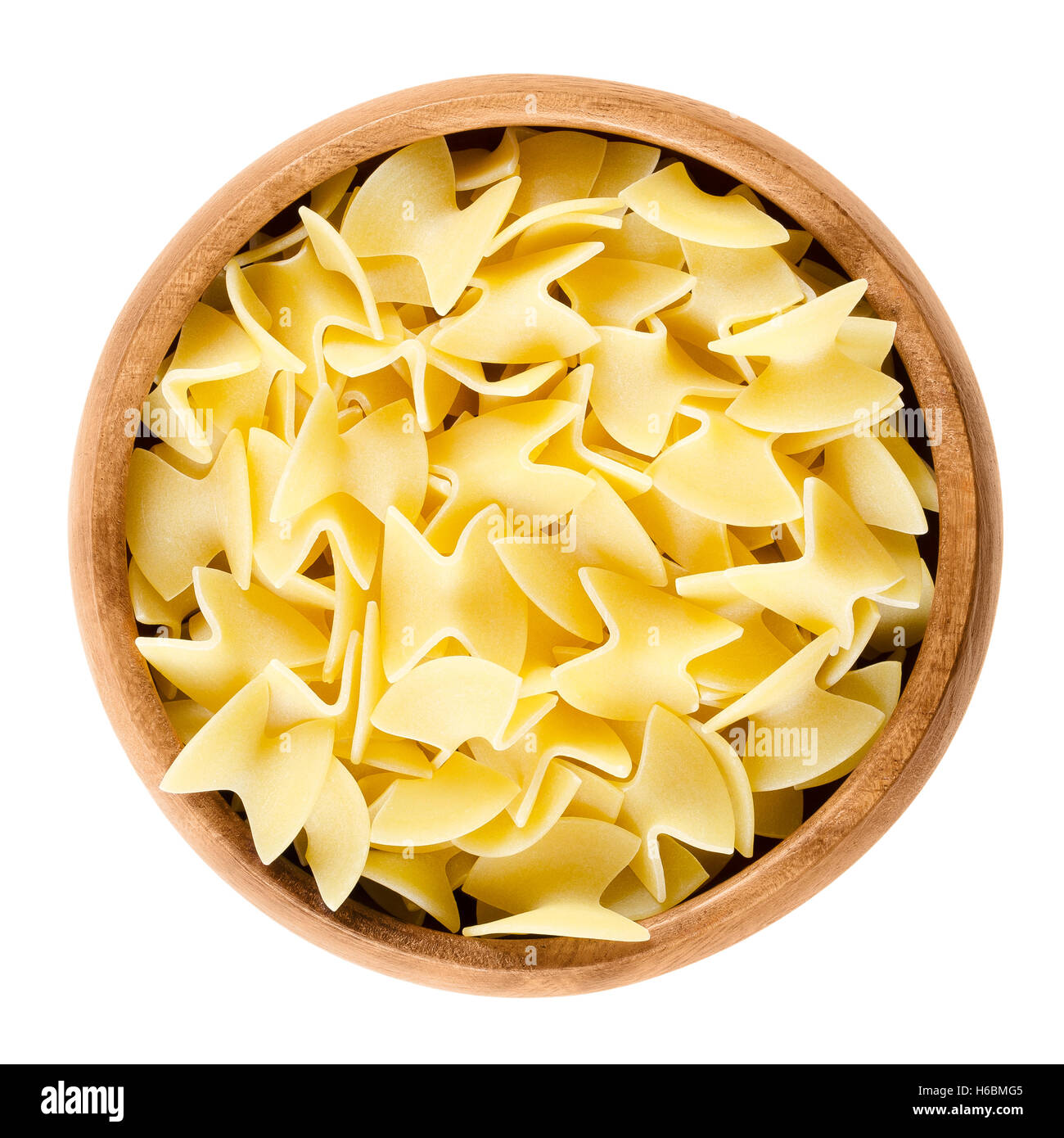 Uncooked egg noodles in wooden bowl over white. Specialty in traditional Austrian cooking, also called Fleckerl. Stock Photo