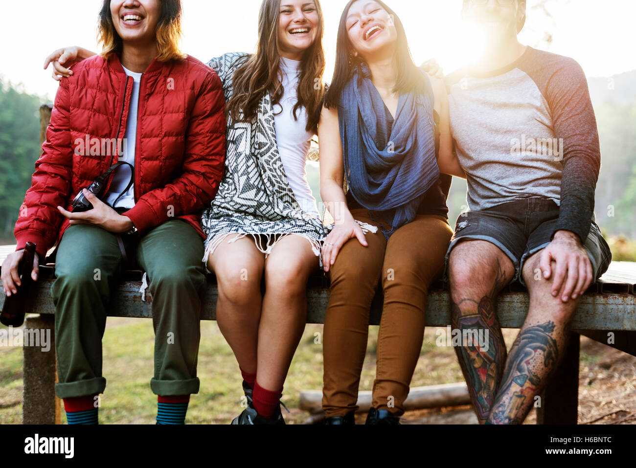 Friends Sitting in a Row Outdoors Concept Stock Photo - Alamy