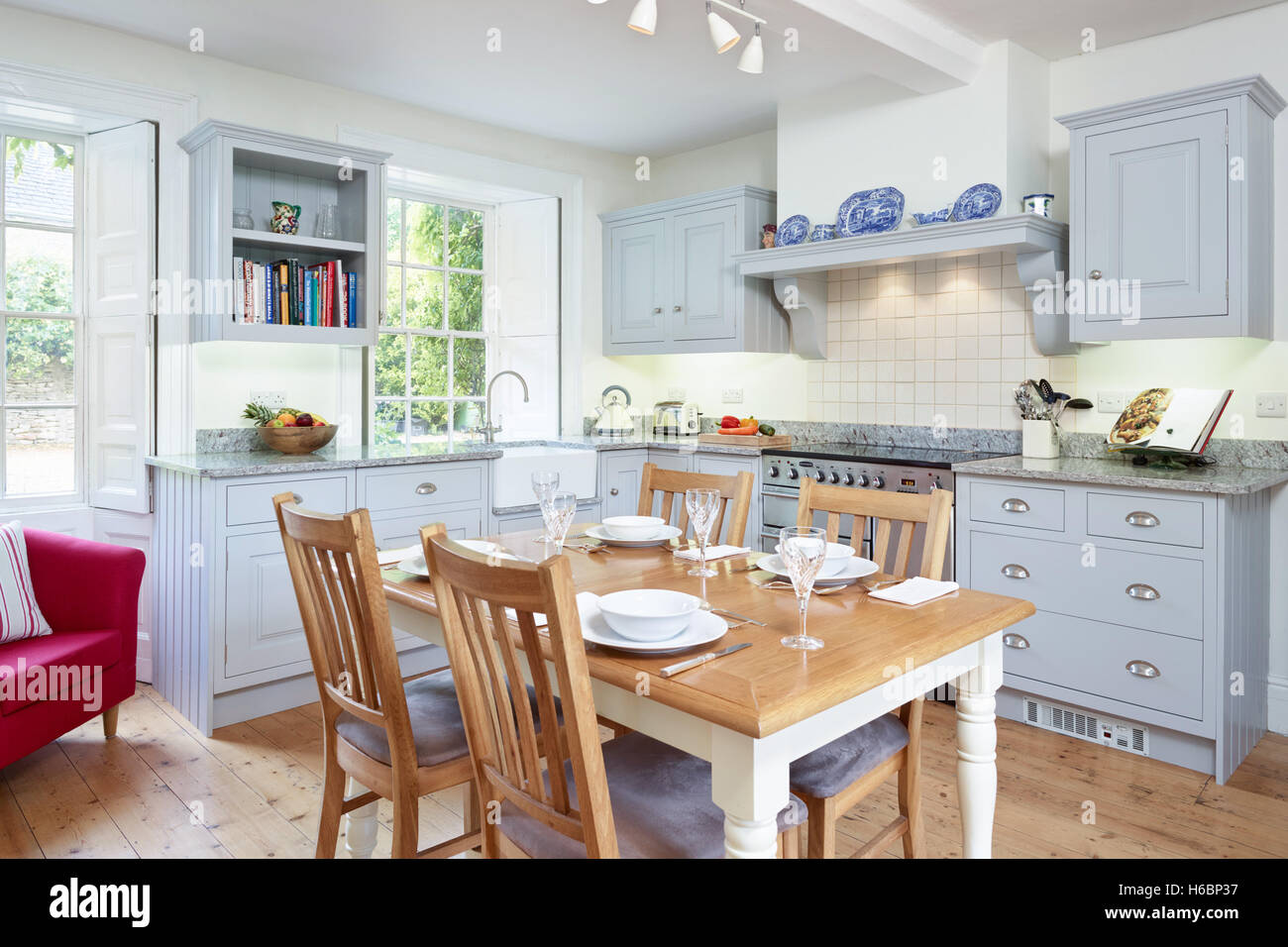 A contemporary, country kitchen incorporating a range cooker, hood & solid wood work surfaces. Gloucestershire, UK Stock Photo
