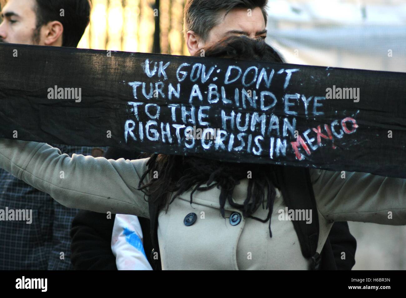 A protester holds a sign that reads 'UK gov: don't turn a blind eye to human rights crisis in Mexico'. Protesters accuse the Mexican police of abducting 43 students of Ayotizinapa and killing 6, and want to raise attention to this during the state visit of Mexican President Peña Nieto to the UK. Stock Photo